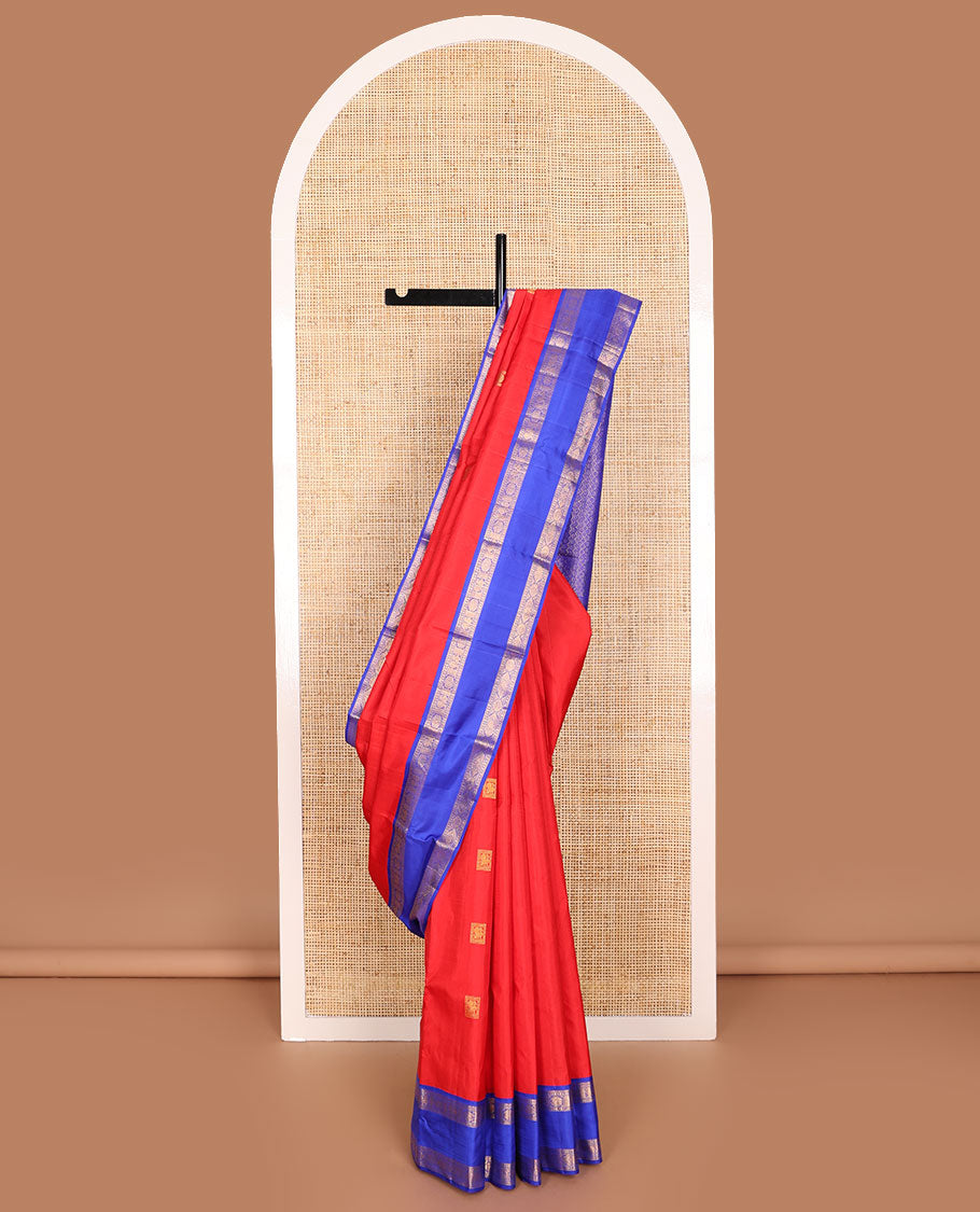 Red zari buttas Kanchipuram silk saree, contrast rettai pettu border of rekku, muthu, diamond, and annam chakram designs, and intricate pallu