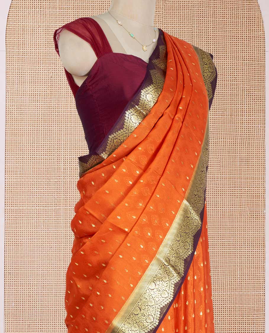 Orange Mysore Silk Saree Subtly Sparkled with Embossed Weave and Zari Buttas All Over Its Body, Complemented by a Contrast Zari Border of Scallop Designs, a Gleaming Pallu of Floral Jaal Design, and a Contrast Blouse