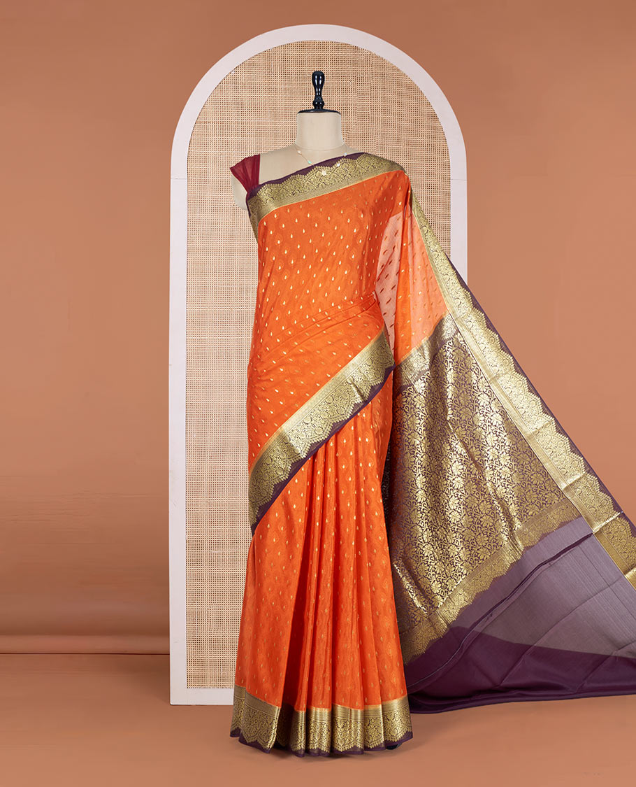 Orange Mysore Silk Saree Subtly Sparkled with Embossed Weave and Zari Buttas All Over Its Body, Complemented by a Contrast Zari Border of Scallop Designs, a Gleaming Pallu of Floral Jaal Design, and a Contrast Blouse