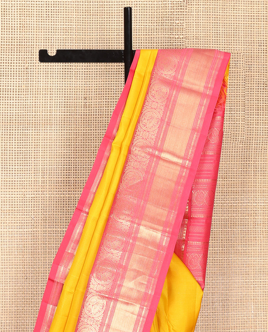 Mango Yellow Vasundhara Silk Saree, Subtly Sparkled with Sparse Stripes and Zari Buttas, Complemented by a Contrast Border of Thilakam, Banaras, Muthu, and Round Mayil Designs, Pallu Steeped with Traditional Designs, and Paired with a Contrast Blouse