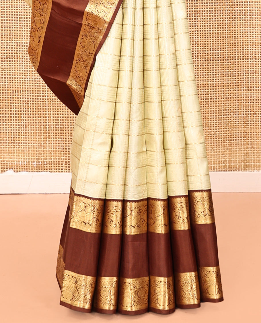 Pale Green Vasundhara Silk Saree, Enriched with Zari Buttas Enclosed Checks All Over Its Body, Complemented by a Contrast Rettai Pettu Border of Muthu, Banaras, and Iruthalai Pakshi Designs, a Grand Pallu, and Paired with a Contrast Blouse