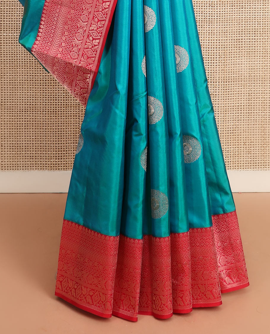 Peacock blue charkam buttas Vasundhara silk saree, contrast border of thilakam mokku, neli, kamalam, kathir, floral, and diamond designs, and Mughal floral woven pallu