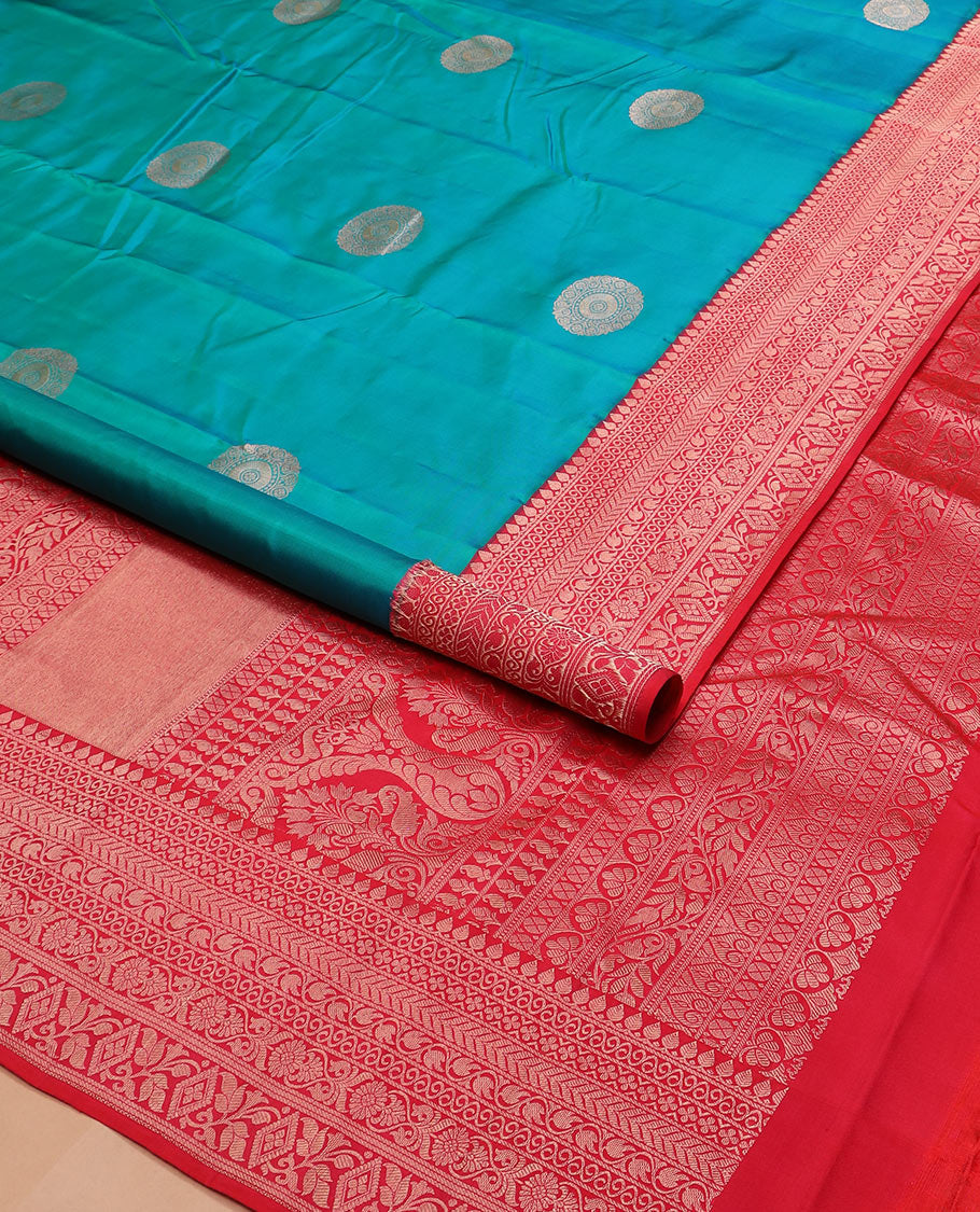 Peacock blue charkam buttas Vasundhara silk saree, contrast border of thilakam mokku, neli, kamalam, kathir, floral, and diamond designs, and Mughal floral woven pallu