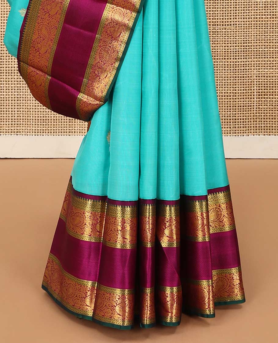 Blue meena buttas Kanchipuram silk saree, contrast korvai border of thilakam mokku, rettai neli, and mayil designs, and geometric patterned pallu