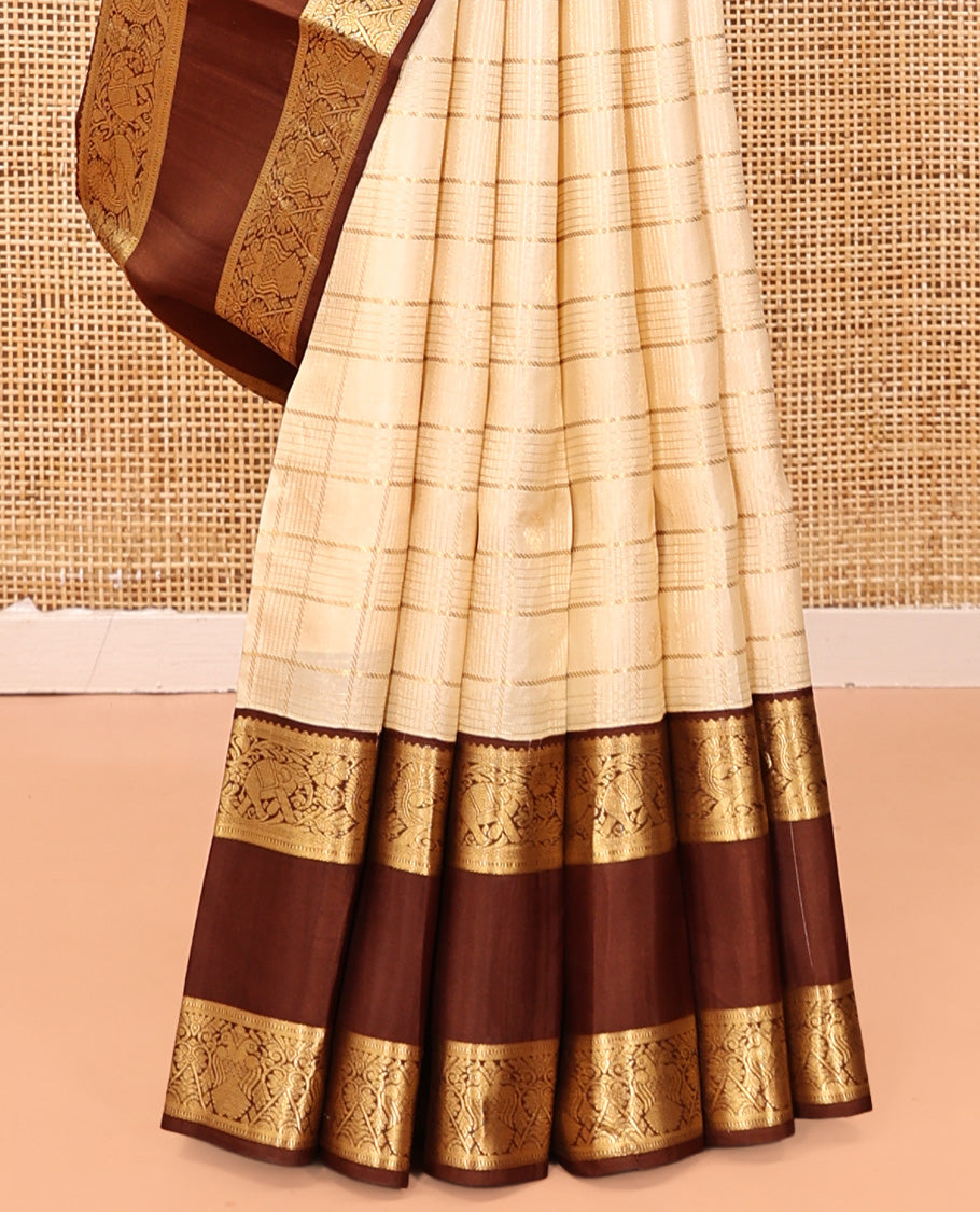 Cream Vasundhara Silk Saree, Enthralled with Zari Buttas Enclosed Checks All Over Its Body, Complemented by a Contrast Rettai Pettu Border of Muthu, Banaras, and Iruthalai Pakshi Designs, a Grand Pallu, and Paired with a Contrast Blouse