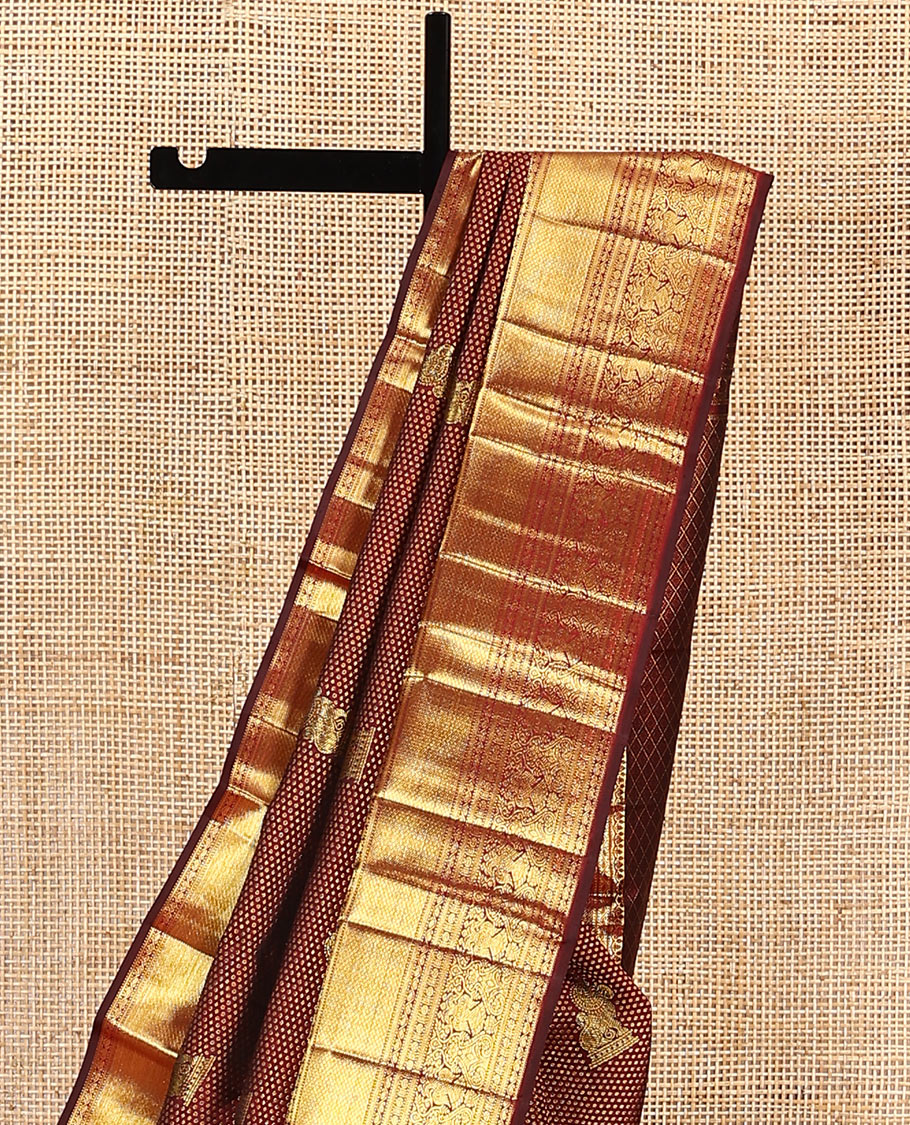 Maroon singam buttas woven kanchipuram silk saree, zari border of muthu, banaras, manga kodi, yaali, kuthirai, yaanai, mayil kann, rudraksham, and iruthalai pakshi, and jaal pallu