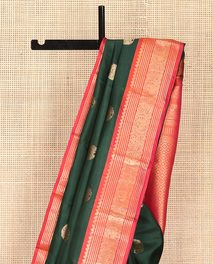 Green Vasundhara Silk Saree, Elevated with Mayil Zari Buttas All Over Its Body, Complemented by a Contrast Border of Thilakam Mokku, Kathir, and Round Mayil Designs, Grand Jaal Pallu, and Paired with a Contrast Blouse