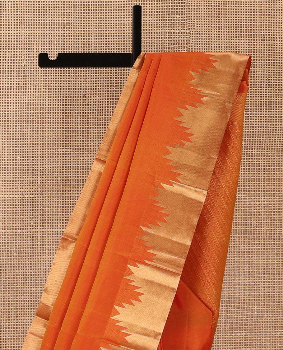 Orange plain Kanchipuram silk saree, thazampoo rekku zari border, and diagonally woven geometric patterned pallu