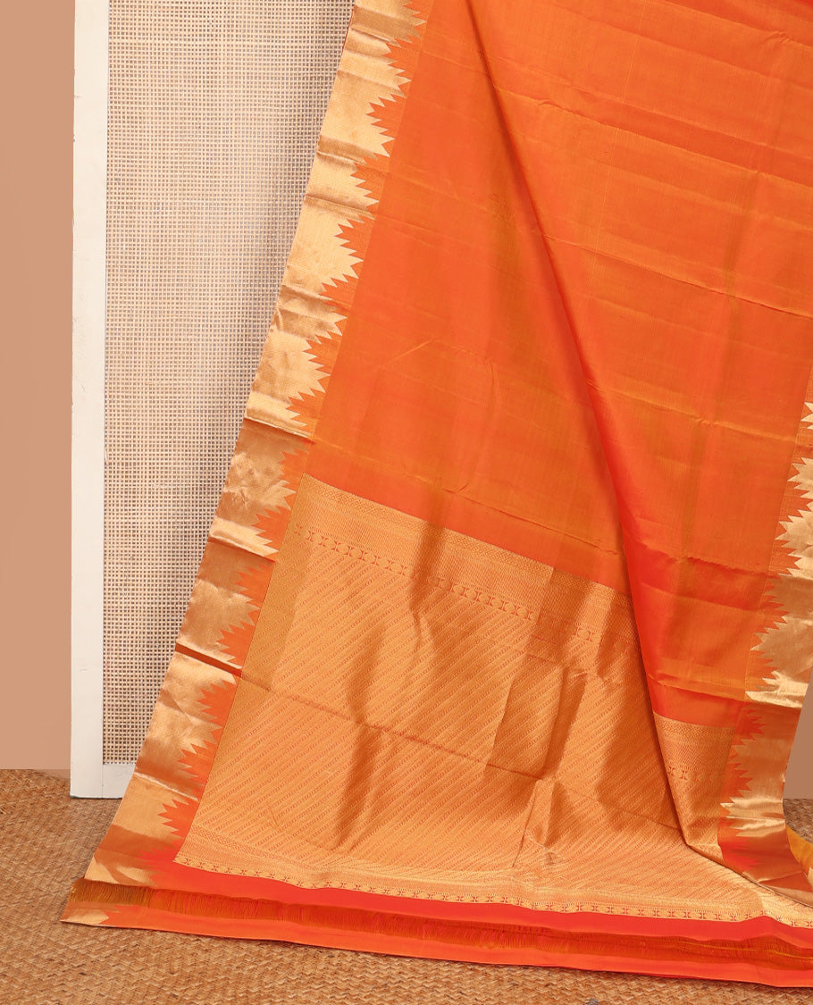 Orange plain Kanchipuram silk saree, thazampoo rekku zari border, and diagonally woven geometric patterned pallu