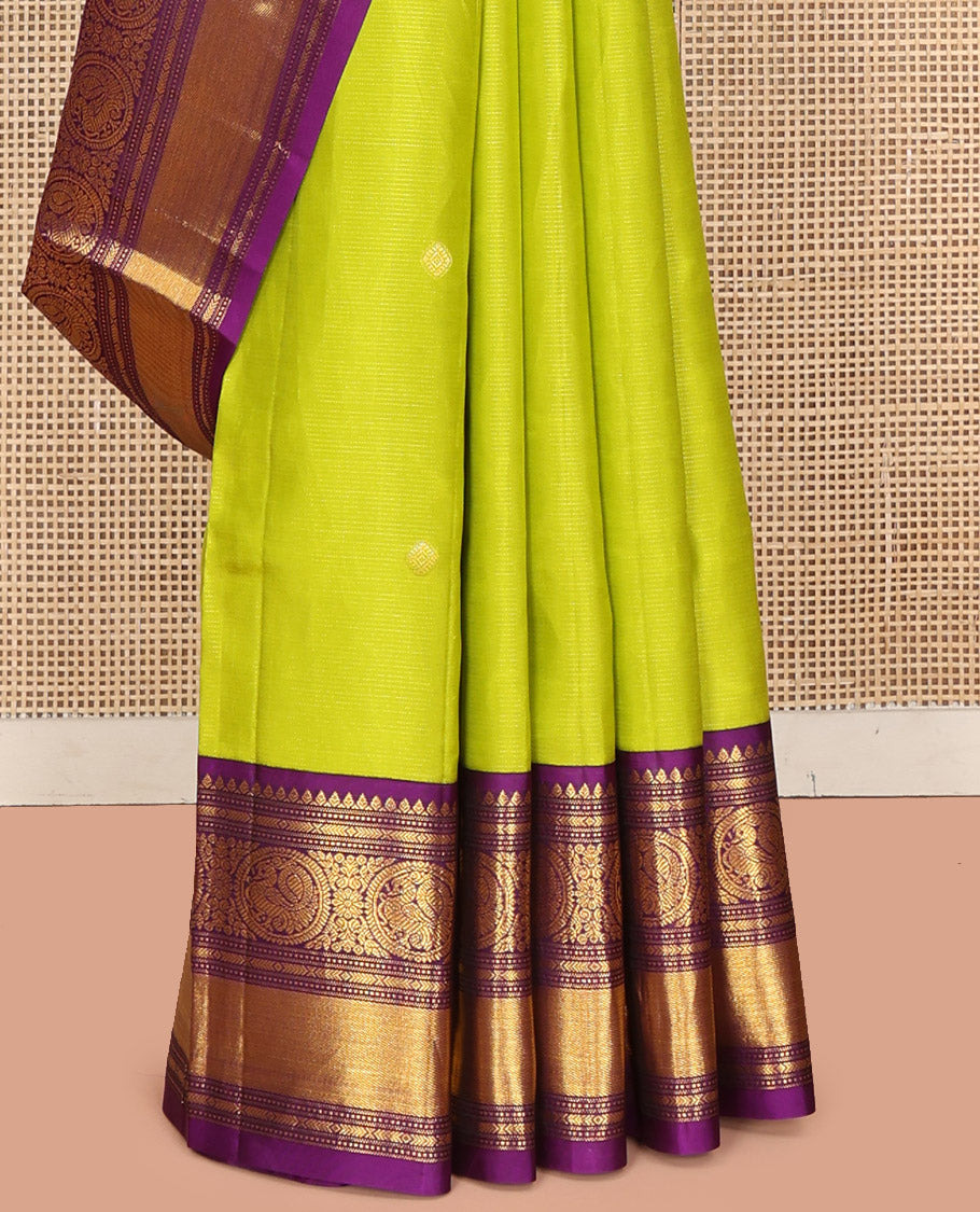 Parrot Green Vasundhara Silk Saree, Enriched with Sparse Stripes and Zari Buttas, Complemented by a Contrast Border of Thilakam, Banaras, Muthu, and Round Mayil Designs, Pallu Steeped with Traditional Designs, and Paired with a Contrast Blouse
