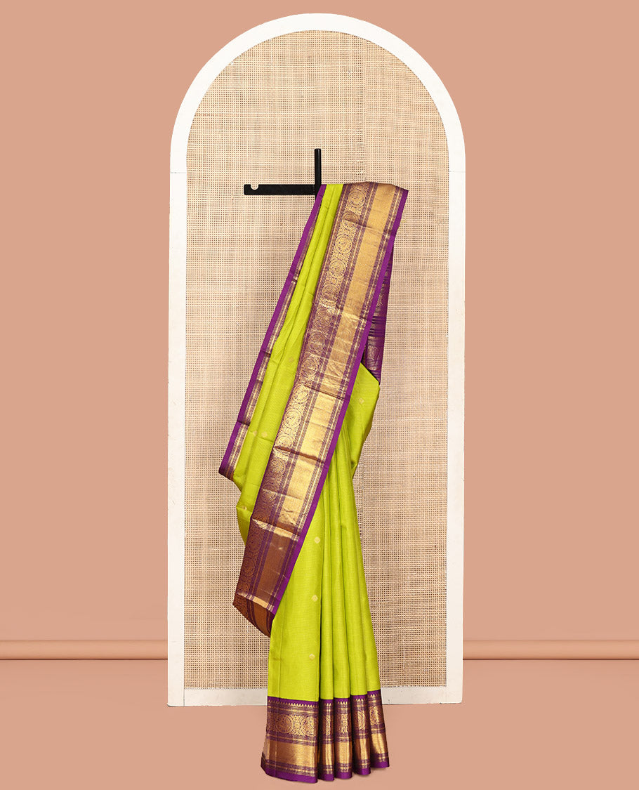 Parrot Green Vasundhara Silk Saree, Enriched with Sparse Stripes and Zari Buttas, Complemented by a Contrast Border of Thilakam, Banaras, Muthu, and Round Mayil Designs, Pallu Steeped with Traditional Designs, and Paired with a Contrast Blouse