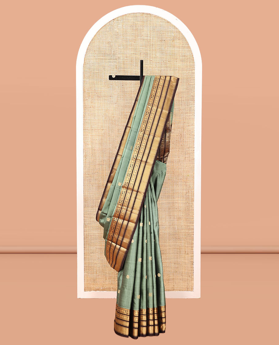 Green Vasundhara Silk Saree, Detailed with Mayil-Chakram Buttas, a Contrast Border of Thikalam, Neli, Kuthirai, Yaanai, Mayil, Chakra, and Mayil Kann, Grand Pallu, and a Contrast Blouse
