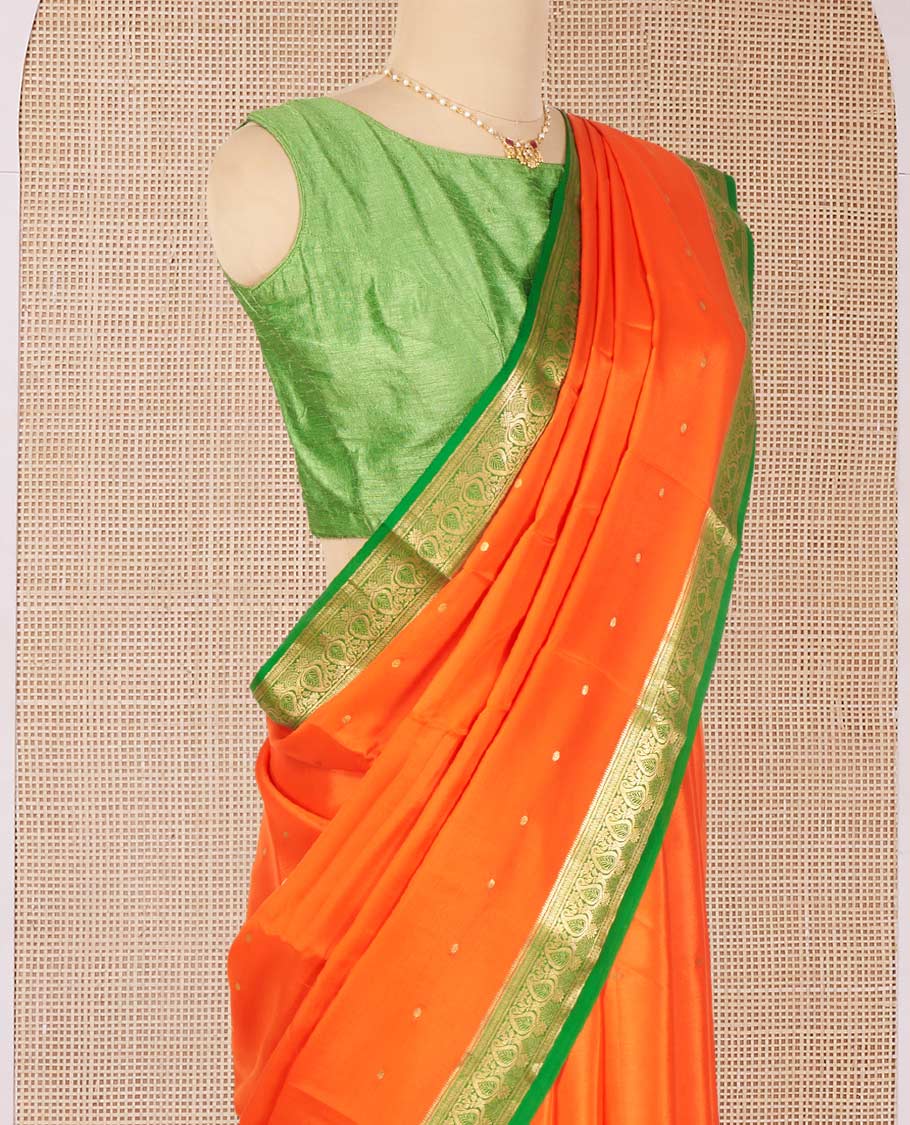 Orange Mysore Silk Saree Enriched with Zari Buttas, Complemented by a Contrast Border Featuring Paisley Zari Designs, Pallu Steeped with Zari Stripes, and Paired with a Contrast Blouse