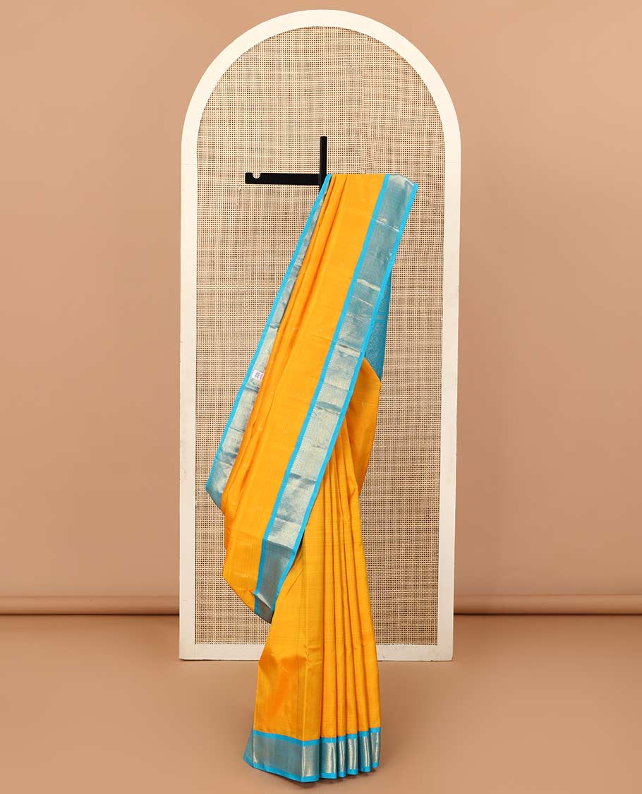 Yellow zari buttas Kanchipuram silk saree, contrast korvai border of thilakam mokku, muthu, and vanki designs, and zari-rich jaal pallu
