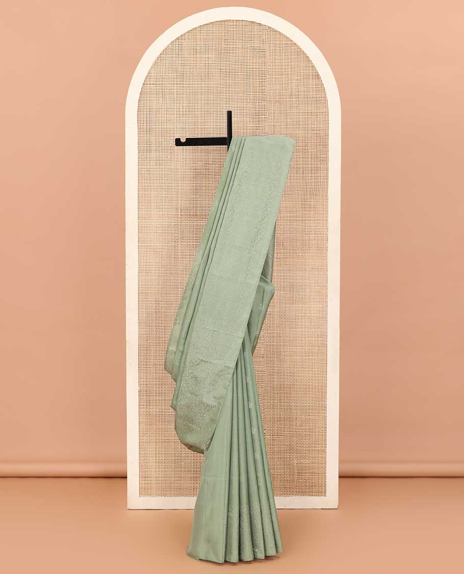 Pastel green floral motifs soft silk saree, floral jaal design border, and pallu of sparesly woven floral jaal design