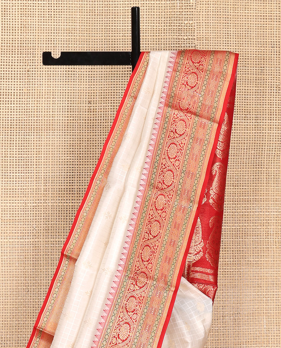 Cream Vasundhara Silk Saree, Subtly Sparkled with Buttas And Checks On Its Body, Complemented by Captivating Contrast Border of Thazampoo Rekku, Muthu, Banaras, and Kodi Visiry Designs, Pallu Steeped with Manga Designs, And Paired with a Contrast Blouse