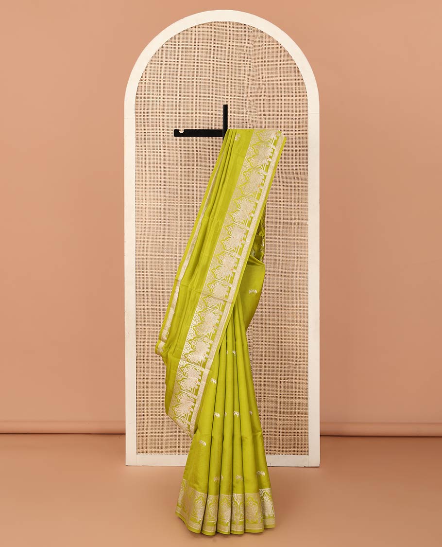 Parrot green zari buttas raw mango silk saree, Mughal border of elephant motifs, and pallu decked up with coconut tree, elephant, and butterflies