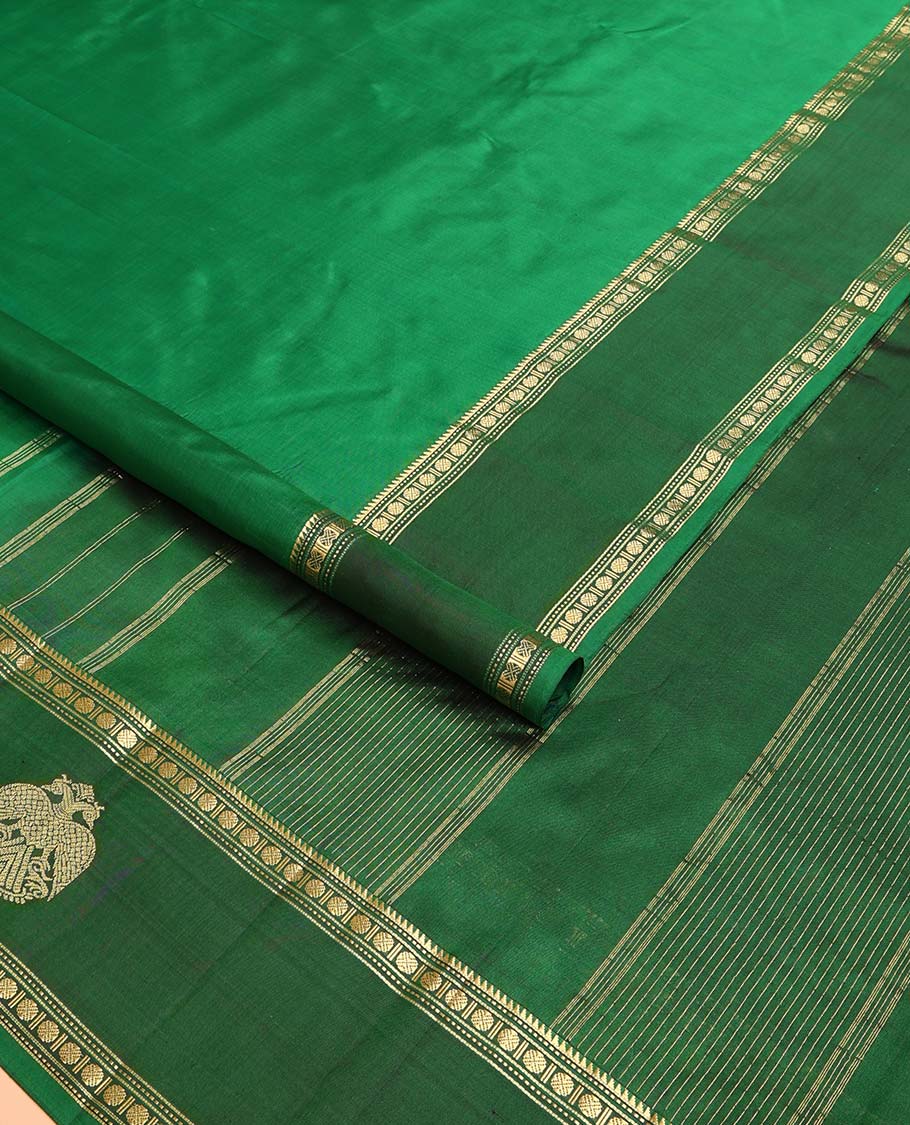 Green plain Kanchipuram silk saree, contrast border of rekku, muthu, rudraksham and iruthalai pakshi motifs, and zari striped pallu