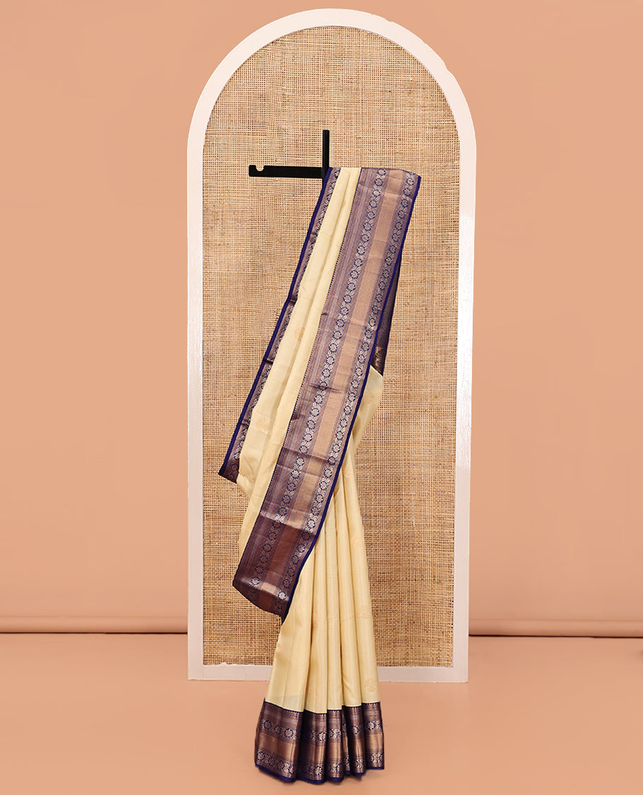 Sandal Vasundhara Silk Saree, Sparsely Sparkled with Zari Buttas, Complemented by a Contrast Border of Thilakam Mokku, Kodi Visiry, and Mayil Kann Designs, Jaal Pallu, and a Contrast Blouse