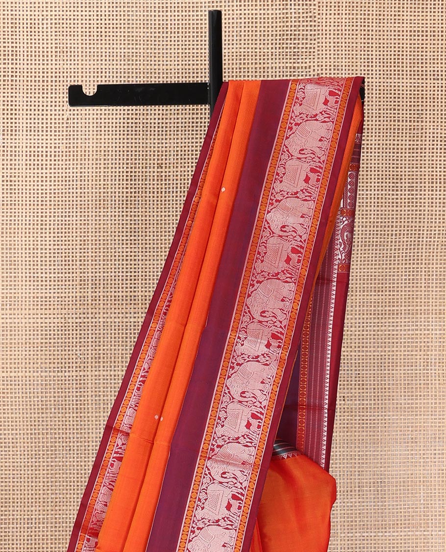 Orange thread buttas Kanchipuram silk saree, contrast rettai pettu border of rekku, rudraksham, yaanai, and Pichwai cow designs, and pallu features Vrishabha Kunjara design