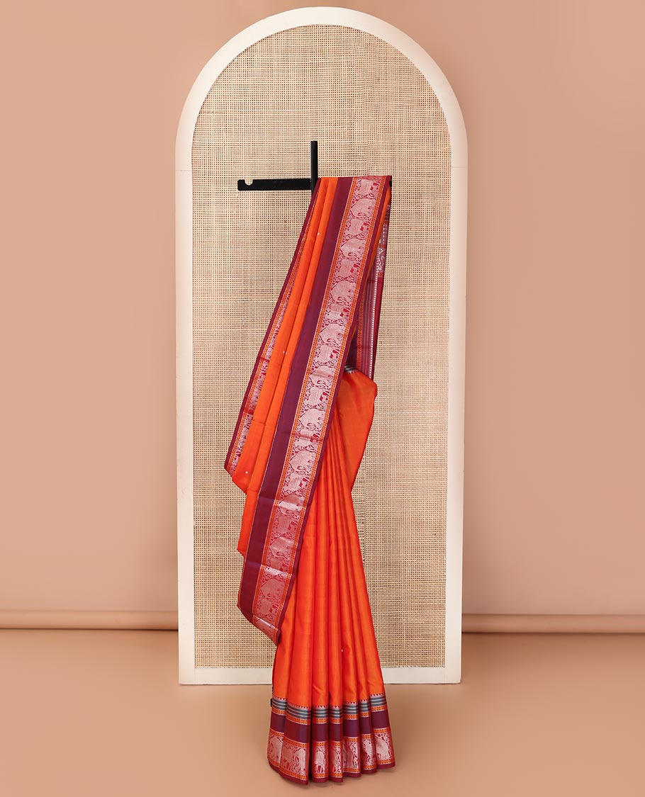 Orange thread buttas Kanchipuram silk saree, contrast rettai pettu border of rekku, rudraksham, yaanai, and Pichwai cow designs, and pallu features Vrishabha Kunjara design