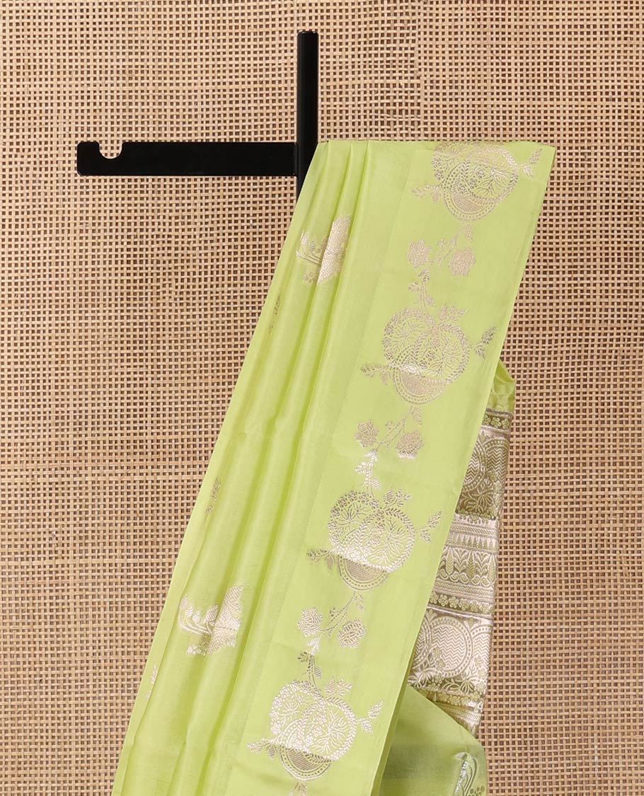 Green floral buttas raw mango silk saree, floral design border, and pallu adorned with floral, and geometric zari designs