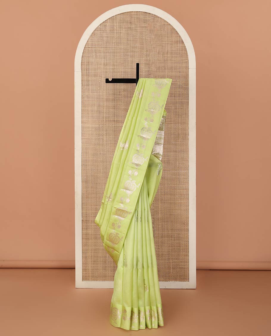 Green floral buttas raw mango silk saree, floral design border, and pallu adorned with floral, and geometric zari designs