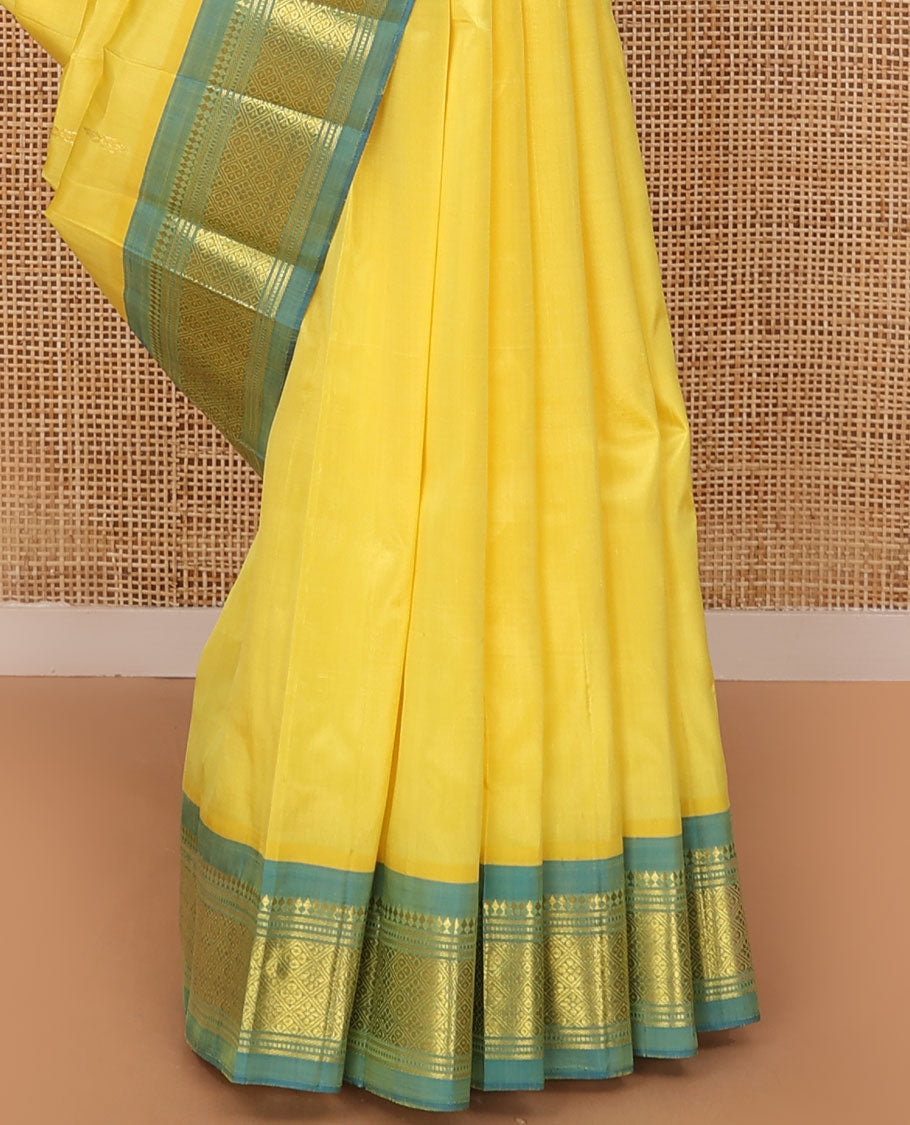 Yellow Kanchipuram silk saree with zari buttas, contrast one-sided border of panner sombu,banaras,muthu & jaal & zari design pallu