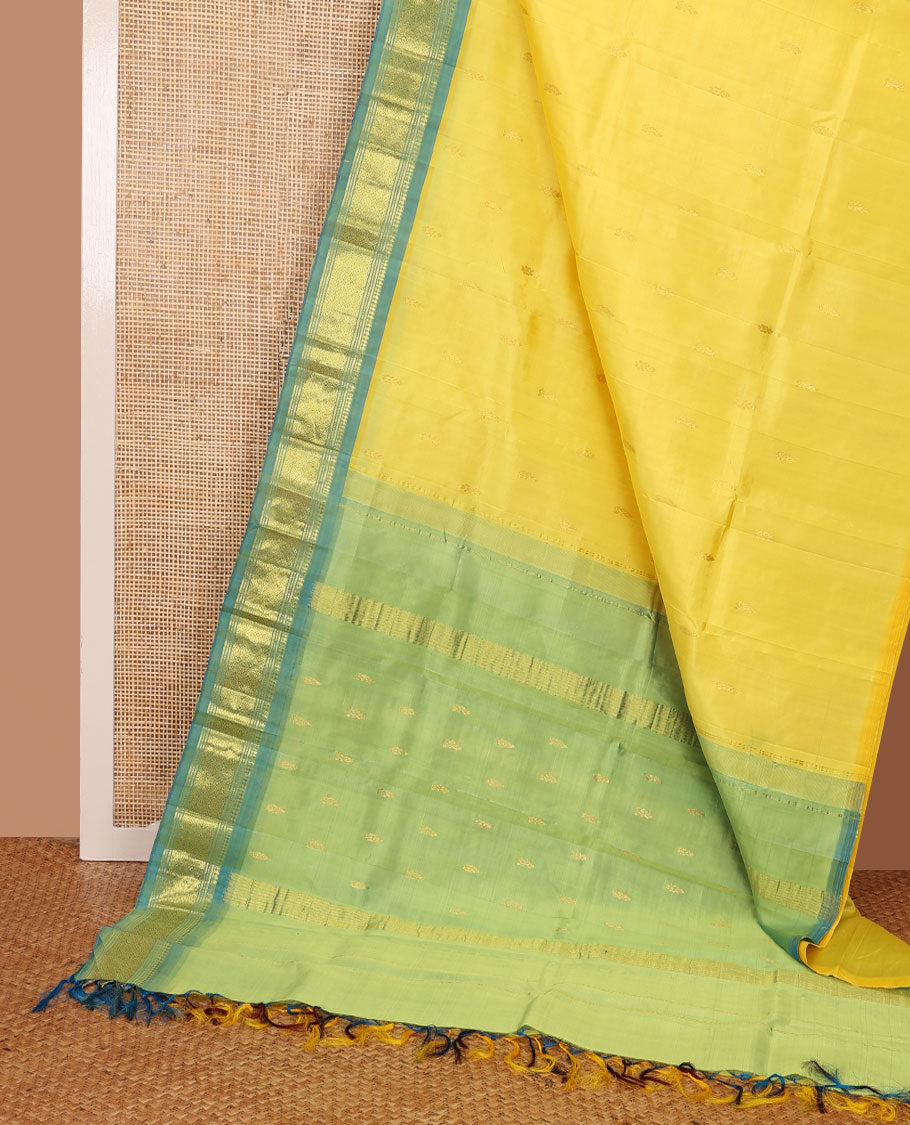 Yellow Kanchipuram silk saree with zari buttas, contrast one-sided border of panner sombu,banaras,muthu & jaal & zari design pallu