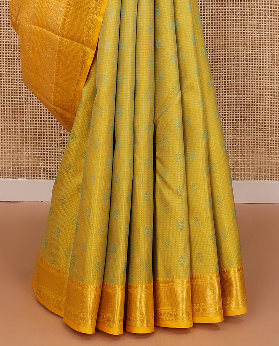 Yellow embossed silk saree, contrast border of thilakam mokku, muthu, ara bogudi, and kuyil kann, and jaal pallu