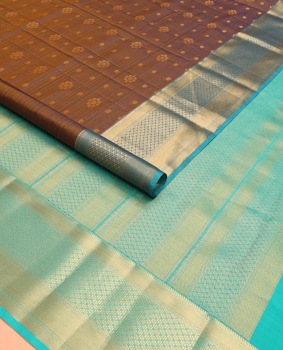 Brown Vasundhara Lite Silk Mix Saree Adorned with Zari Buttas, Complemented by a Contrast Border Featuring Ara Bogudi, Kathir, and Floral Designs, a Pallu Showcasing Floral Motifs, Paired with a Contrast Blouse