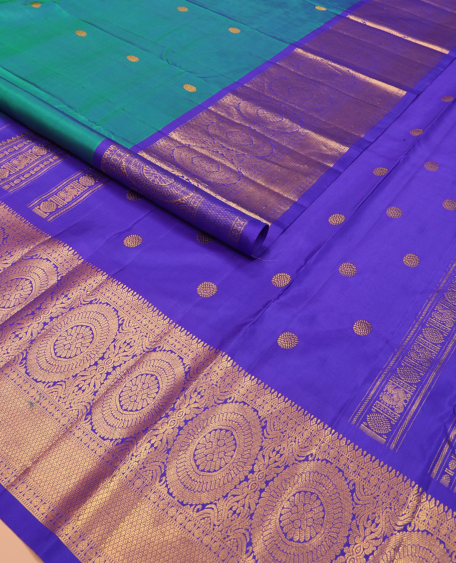 Blue chakram buttas Kanchipuram silk saree, contrast border of muthu, rudraksham, poo chakram, and mayil kann designs, and chakram motifs pallu