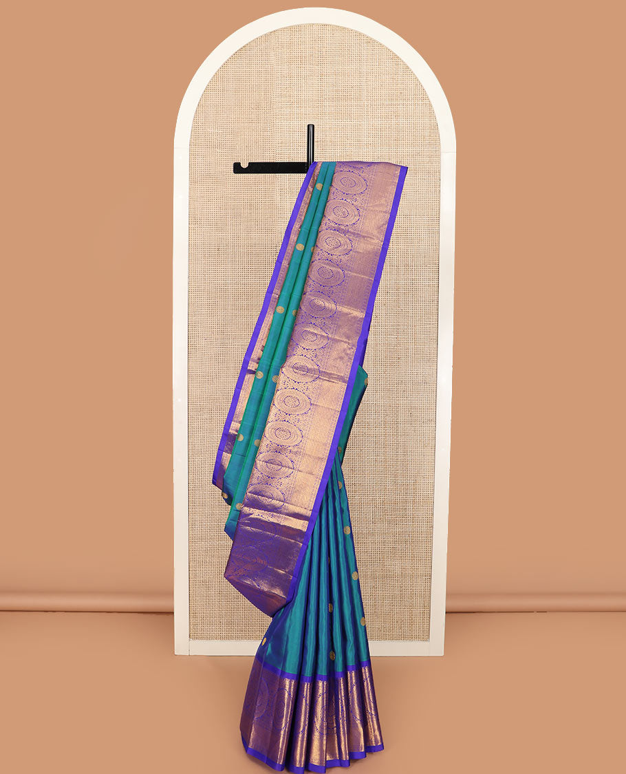 Blue chakram buttas Kanchipuram silk saree, contrast border of muthu, rudraksham, poo chakram, and mayil kann designs, and chakram motifs pallu