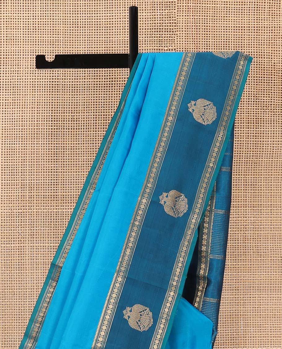 Blue plain Kanchipuram silk saree, contrast border of rekku, muthu, rudraksham and iruthalai pakshi motifs, and zari striped pallu