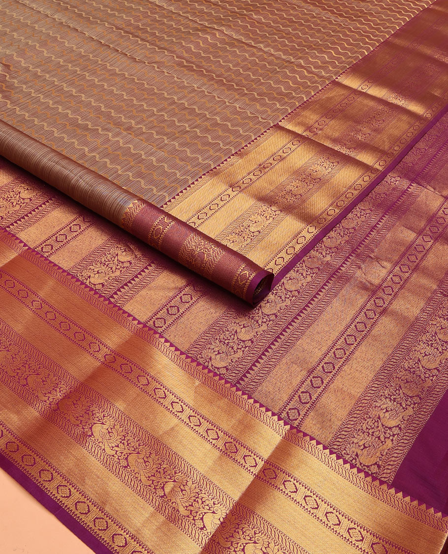 Brown Vasundhara Lite Silk Mix Saree Showcasing Zig-Zag Stripes Across the Body, Enhanced by a Contrast Border Adorned with Rekku, Puli Nagam, Laddu Kamalam, and Mayil Motifs, Complemented with a Zari-Woven Pallu and a Contrast Blouse