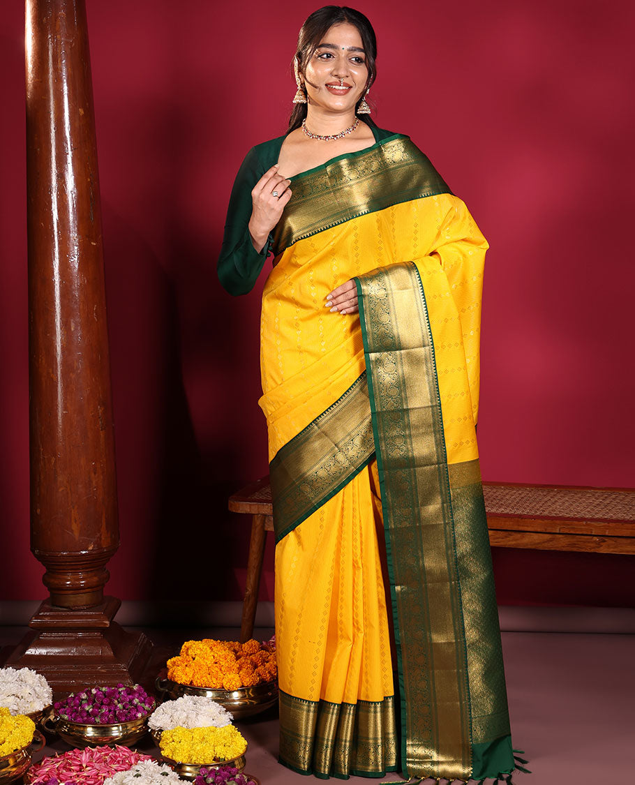 Yellow Budget Silk Saree, Richly Detailed with Zari Muthu, and Zari Buttas on Its Body, Complemented by a Contrast Traditional Zari Design Border of Peacock Designs, Gleaming Jaal Pallu, and Paired with a Contrast Blouse