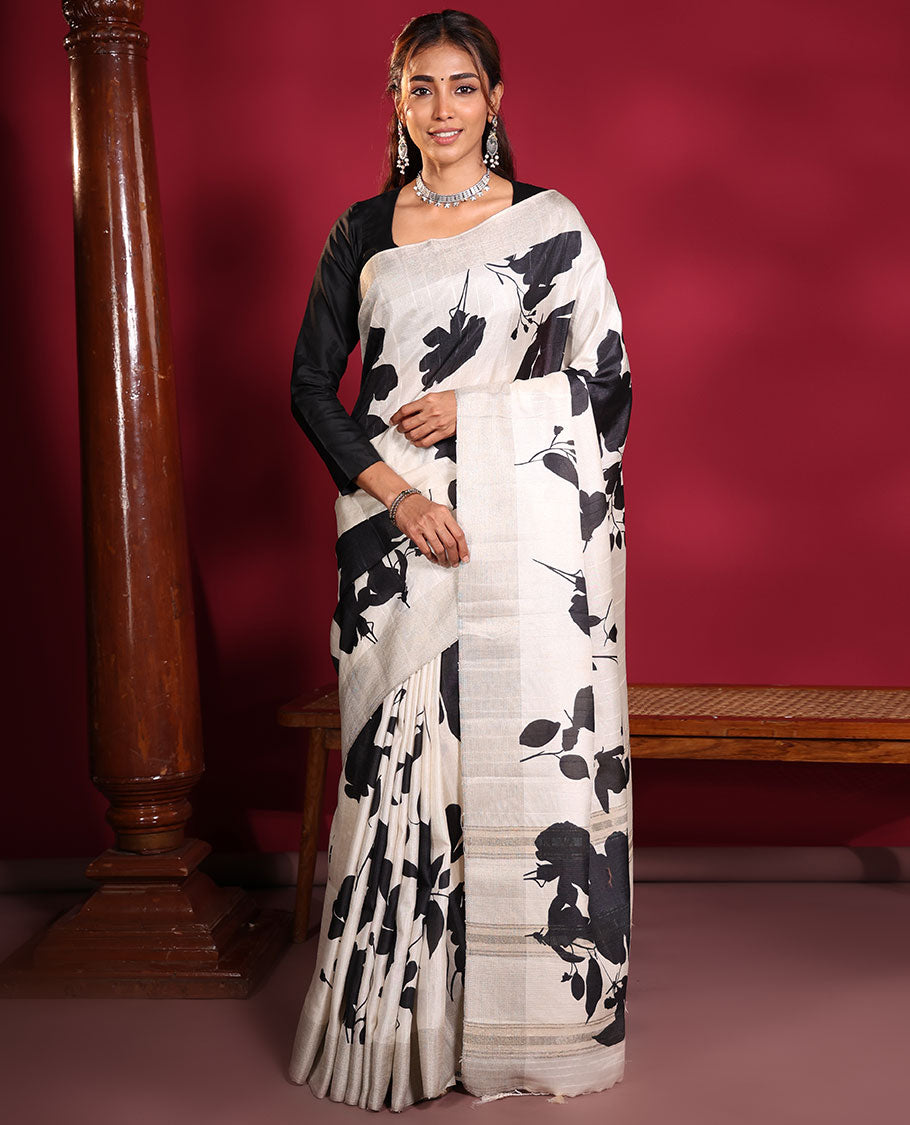 Cream Fancy Tussar Saree, Artfully Detailed with Silhouette-Style Floral Motifs Printed on Its Body, Subtle Zari-Textured Border, Pallu Pictures the Same Floral Print, and Paired with a Matching Blouse