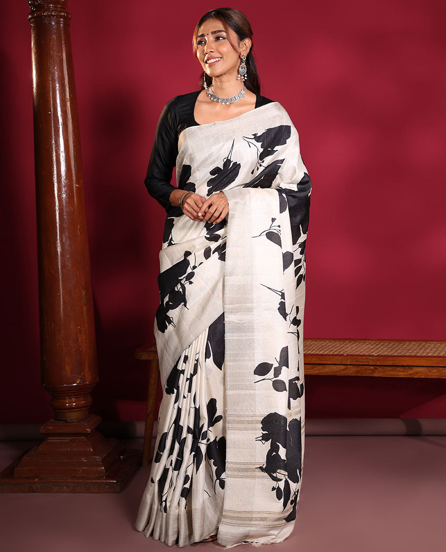 Cream Fancy Tussar Saree, Artfully Detailed with Silhouette-Style Floral Motifs Printed on Its Body, Subtle Zari-Textured Border, Pallu Pictures the Same Floral Print, and Paired with a Matching Blouse