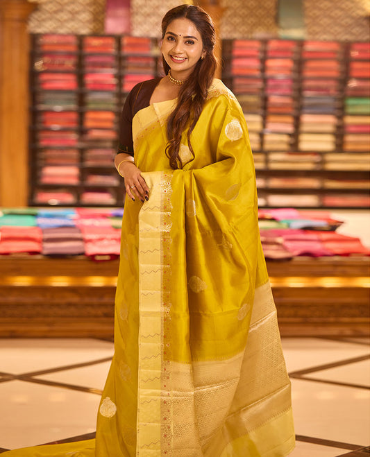 Mustard unblossomed flower-shape zari buttas raw mango silksaree,satin embossed border of meenakari zari floral vine & scallop jacquard pallu