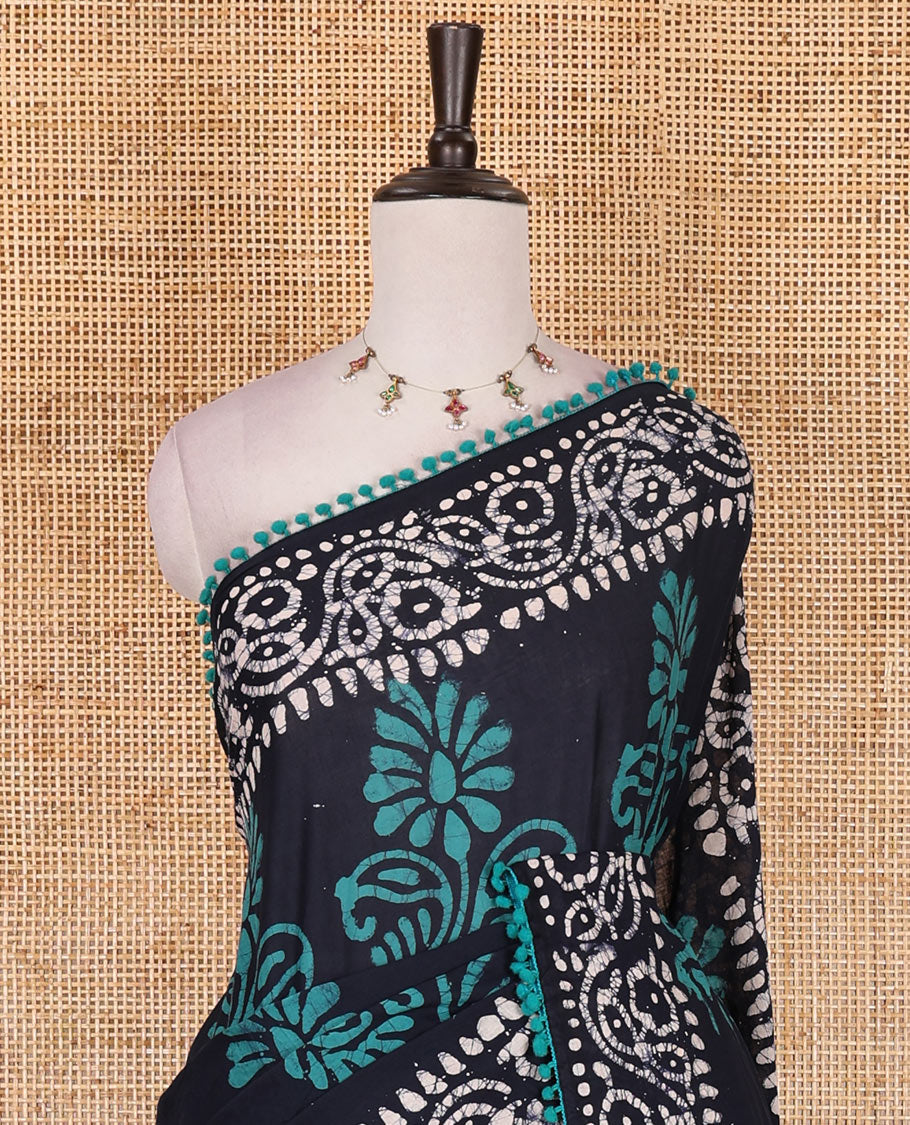 Navy blue-green batik floral printed soft cotton saree, batik printed pom-pom tasseled border, batik floral printed pallu, and a matching blouse