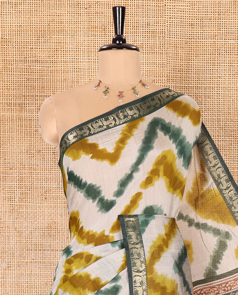 Green Muslin Cotton Saree Spotlighted with Zig-Zag Shibori Patterns Prints, Complemented by a Contrast Border of Deer Motifs in Zari, Pallu Decked Up with Scenery Print, and Paired with a Contrast Polka Dots Printed Blouse