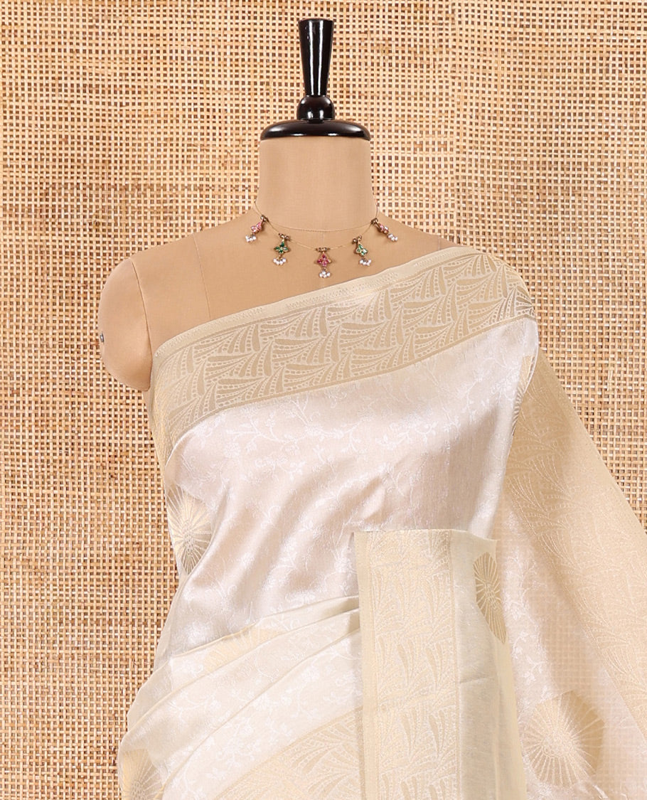 Cream Semi Tussar Saree Embellished with Floral Vine Embossed and Zari Buttas, Gleaming Border of Geometric Designs, Pallu Majestically Detailed with Geometric Designs in Zari, and Paired with a Matching Blouse