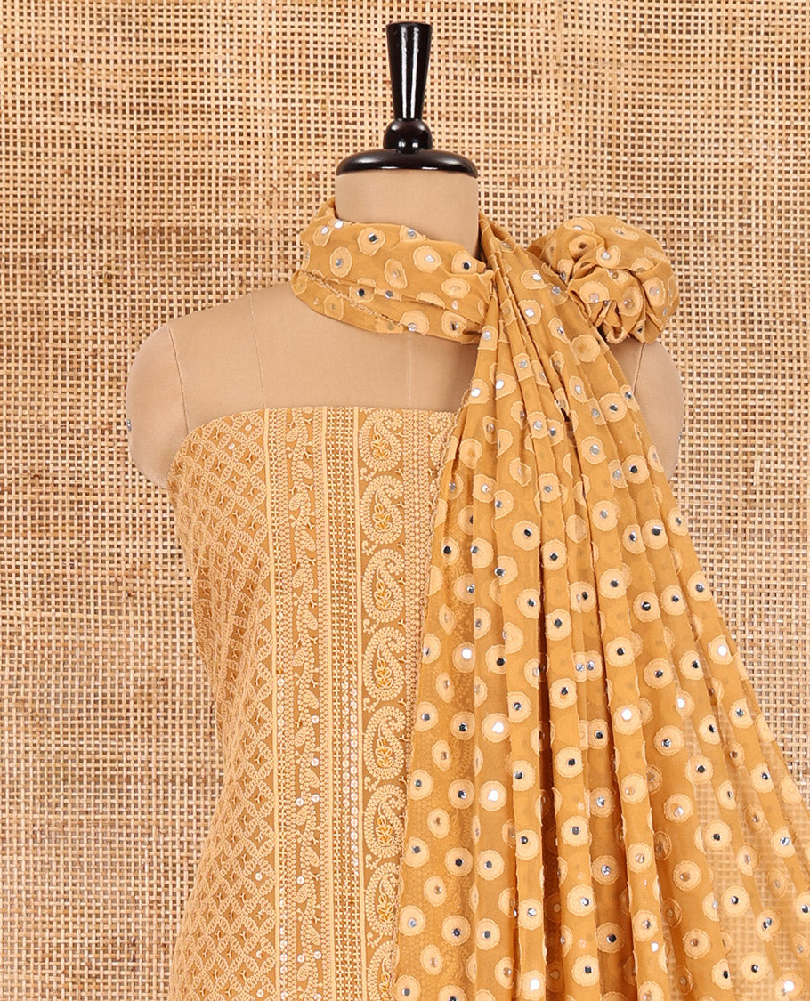 Brown material chudidar set, paisleys and jaal schiffli sequins embroidered mul georgette top, a matching bottom, and a mirror work dupatta