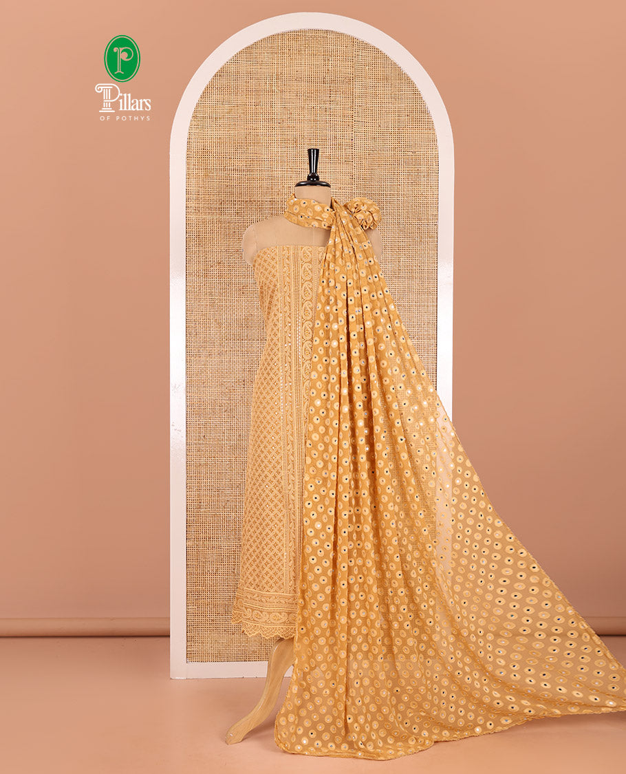Brown material chudidar set, paisleys and jaal schiffli sequins embroidered mul georgette top, a matching bottom, and a mirror work dupatta
