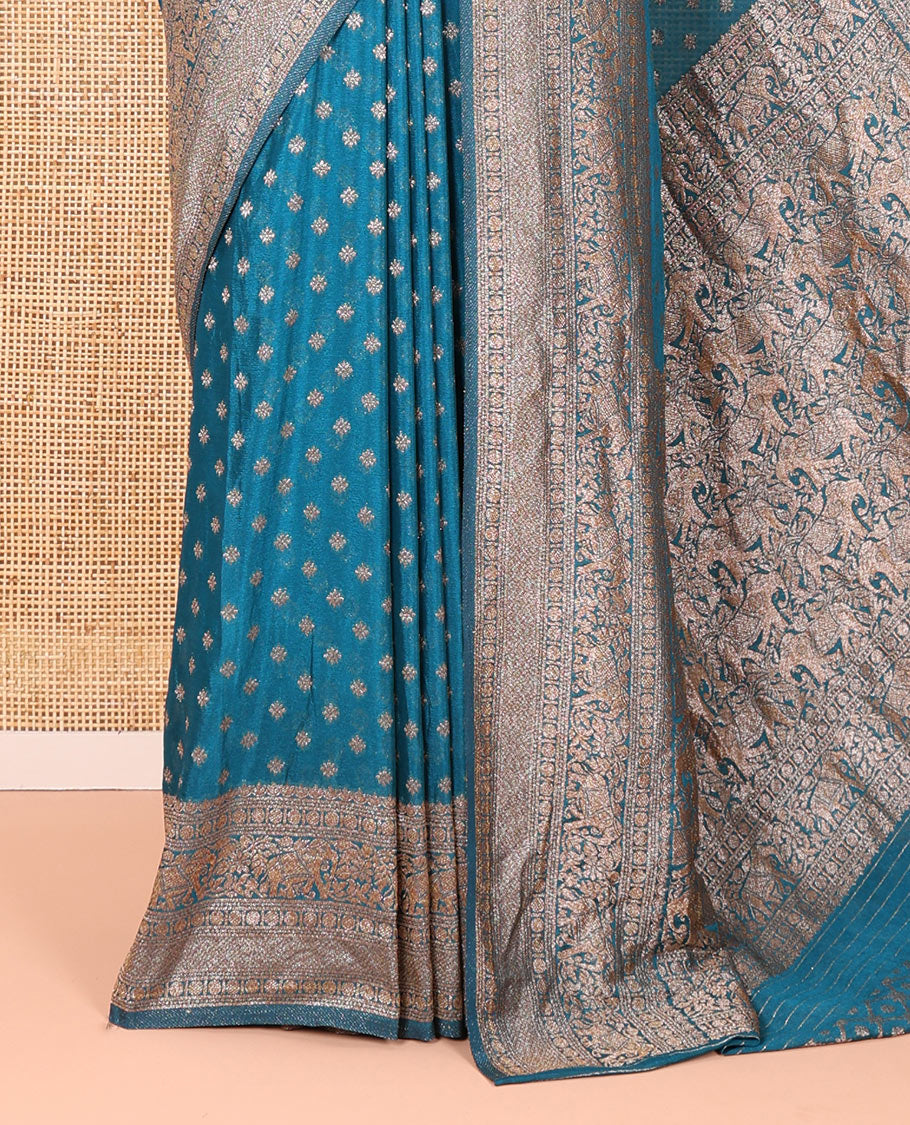 Blue Semi-Banaras Khaddi Georgette Embellished with Zari Buttas All Over Its Body, Subtly Sparkled Traditional Border of Rudraksham, Elephant, and Floral Vine Designs, Pallu of a Herd of Elephants, and Paired with a Matching Blouse