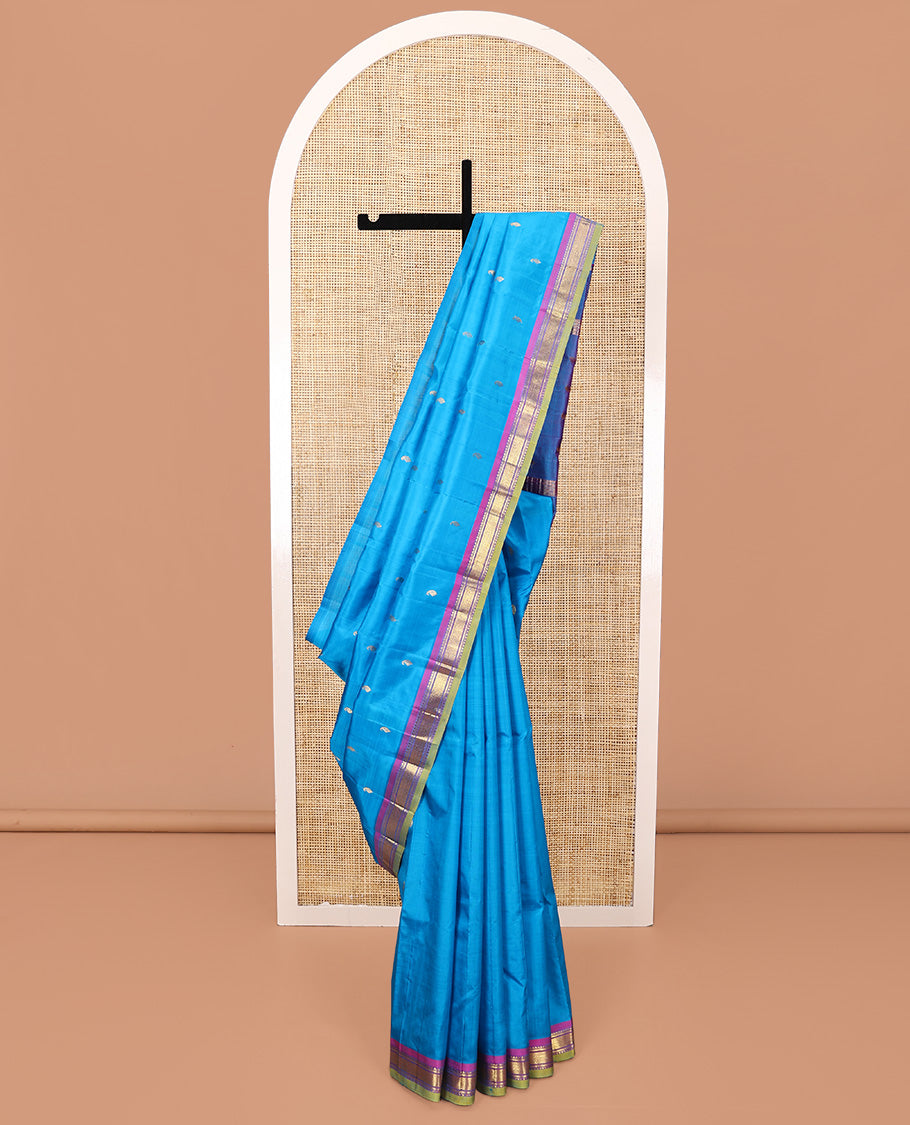 Blue Kanchipuram Silk Saree, Adorned with Zari Buttas All Over Its Body, Complemented by a Contrast One-Sided Border of Rekku, Banaras, and Mayil Kann Designs, Pallu of Zari Designs, and Comes Without a Blouse