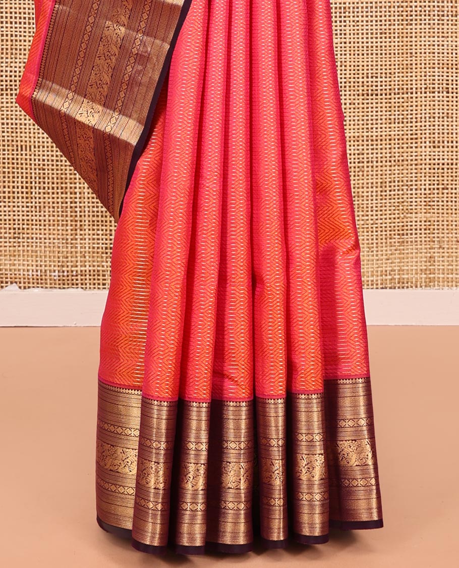 Orange Vasundhara Silk Saree, Gleamed Up with Stripes All Over Its Body, Complemented by a Contrast Border of Thilakam Mokku, Kathir, Vanki, Laddu Kamalam, and Mayil Designs, Intricately Designed Pallu, and Paired with a Contrast Blouse