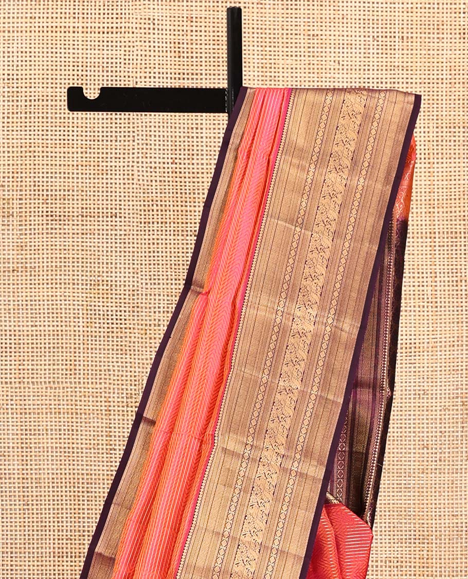 Orange Vasundhara Silk Saree, Gleamed Up with Stripes All Over Its Body, Complemented by a Contrast Border of Thilakam Mokku, Kathir, Vanki, Laddu Kamalam, and Mayil Designs, Intricately Designed Pallu, and Paired with a Contrast Blouse