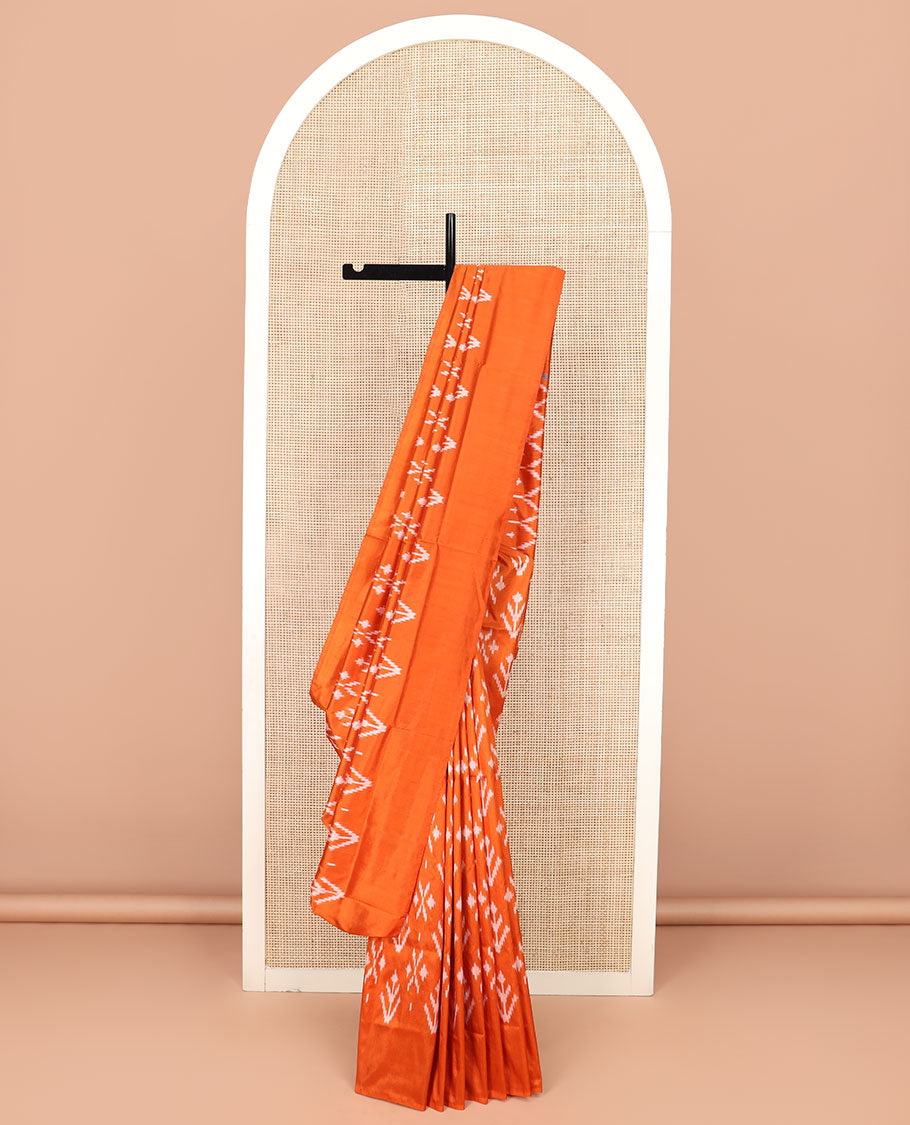 Orange Ikkat Silk Saree Decked with Ikkat Buttas, Featuring a Subtle Plain Border, Complemented by a Pallu Woven in an Ogee Pattern with Ikkat Texture