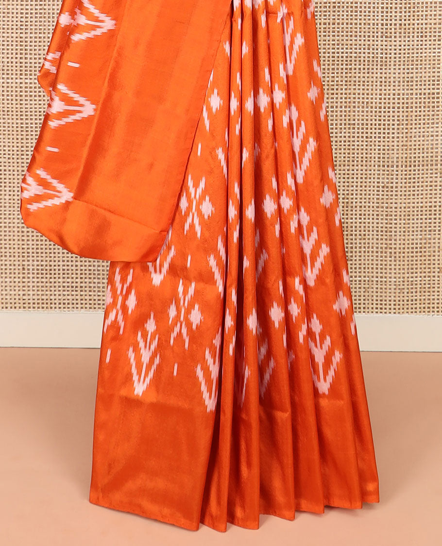 Orange Ikkat Silk Saree Decked with Ikkat Buttas, Featuring a Subtle Plain Border, Complemented by a Pallu Woven in an Ogee Pattern with Ikkat Texture